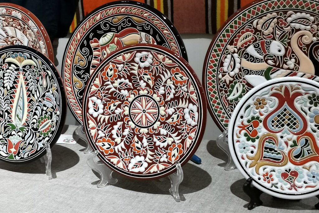Round ceramic plates, arranged in a row, brightly painted with plant patterns