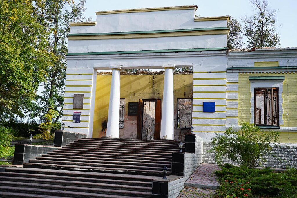 Вхід до музею з колонами; частина даху обвалилася, двері зруйновано