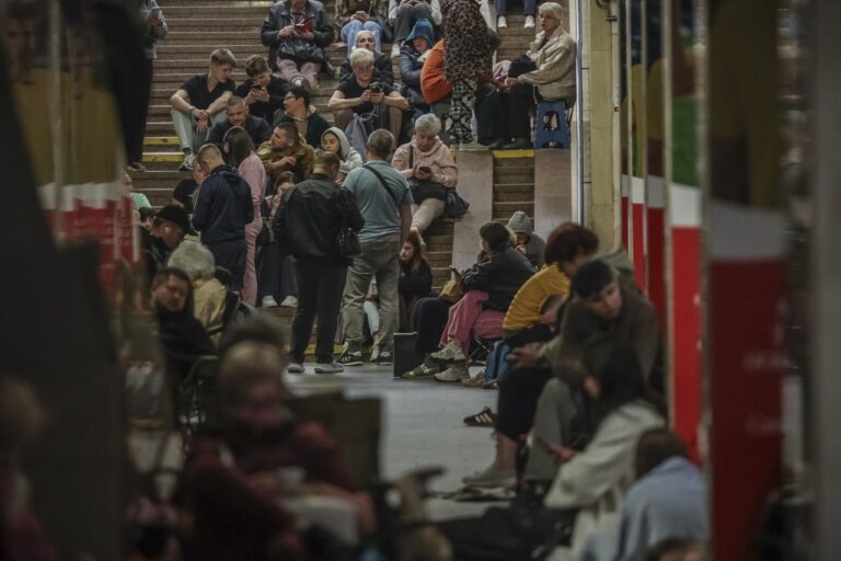地下鉄駅の階段や通路で、大勢の人が座ったり立ったりして過ごしている夜間の空襲警報時の様子