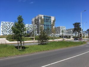 格子状のガラスと金属パネルで覆われた現代的な建物群。青空を背景に並ぶ