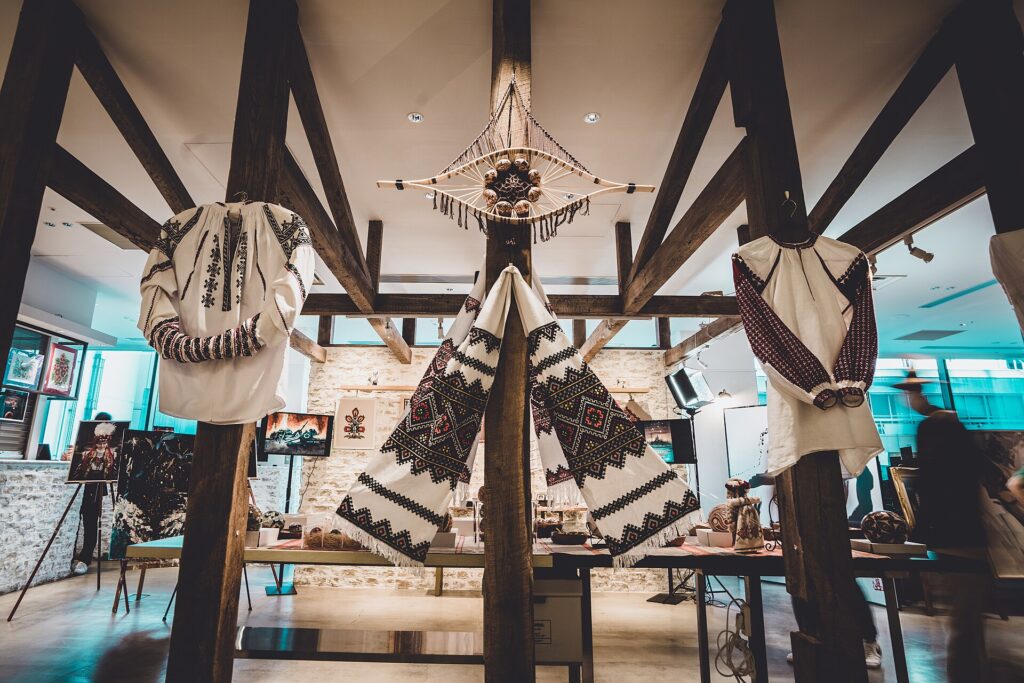 An embroidered shirt and an embroidered rushnyk cloth hanging on a wooden beam