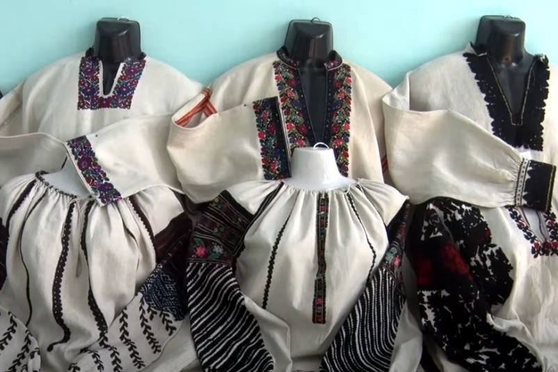 White shirts embroidered with black thread, on display